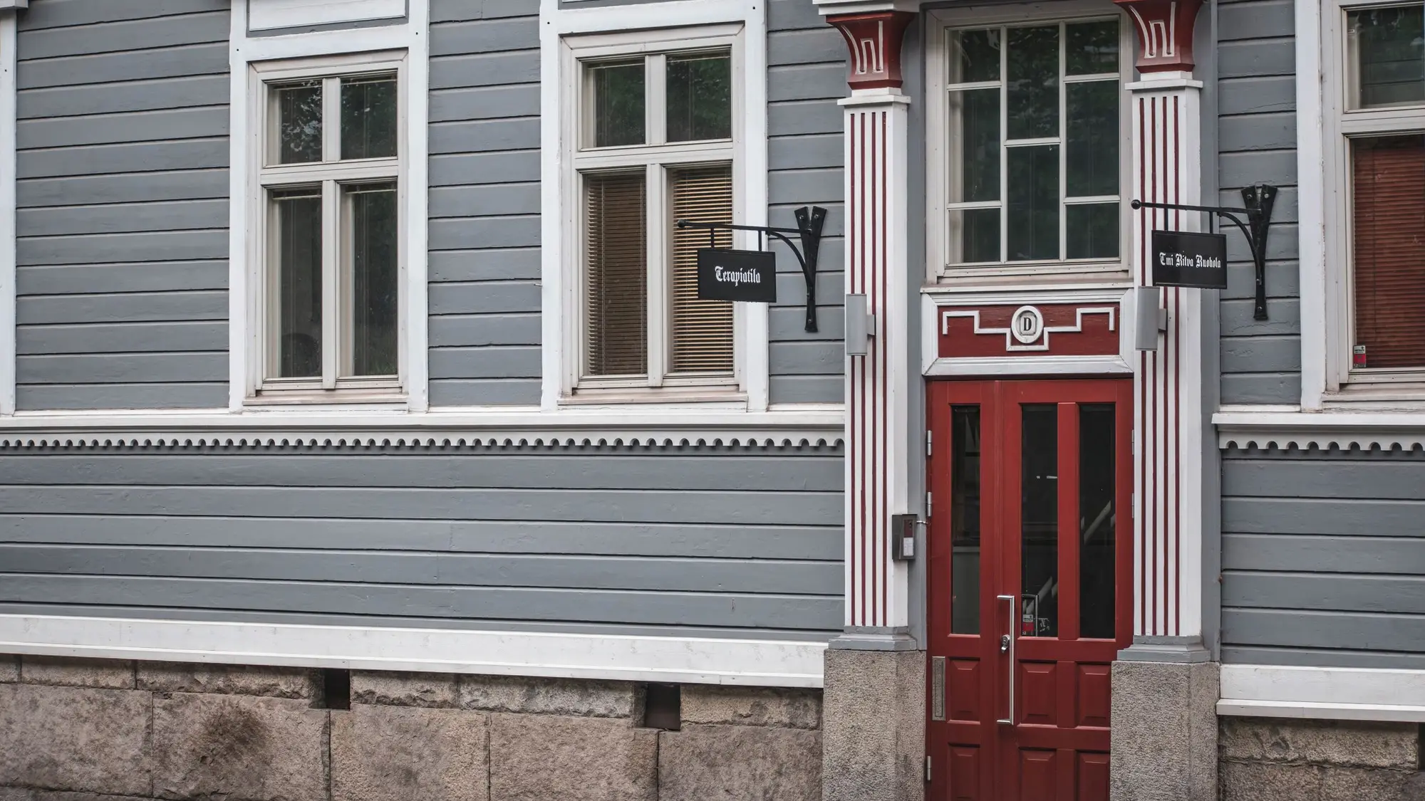 Puutalon julkisivu ja ovi talvisessa suomalaisessa kaupungissa