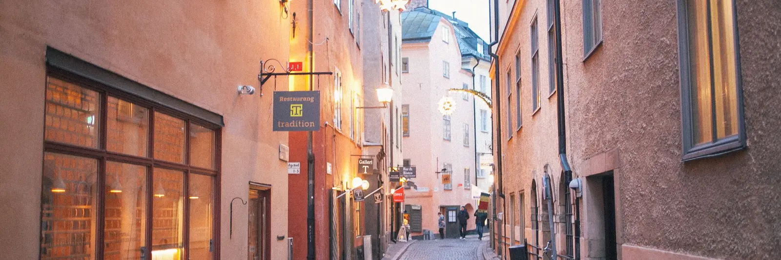 Valaistut ikkunat vanhan kaupungin kadulla iltahämärässä